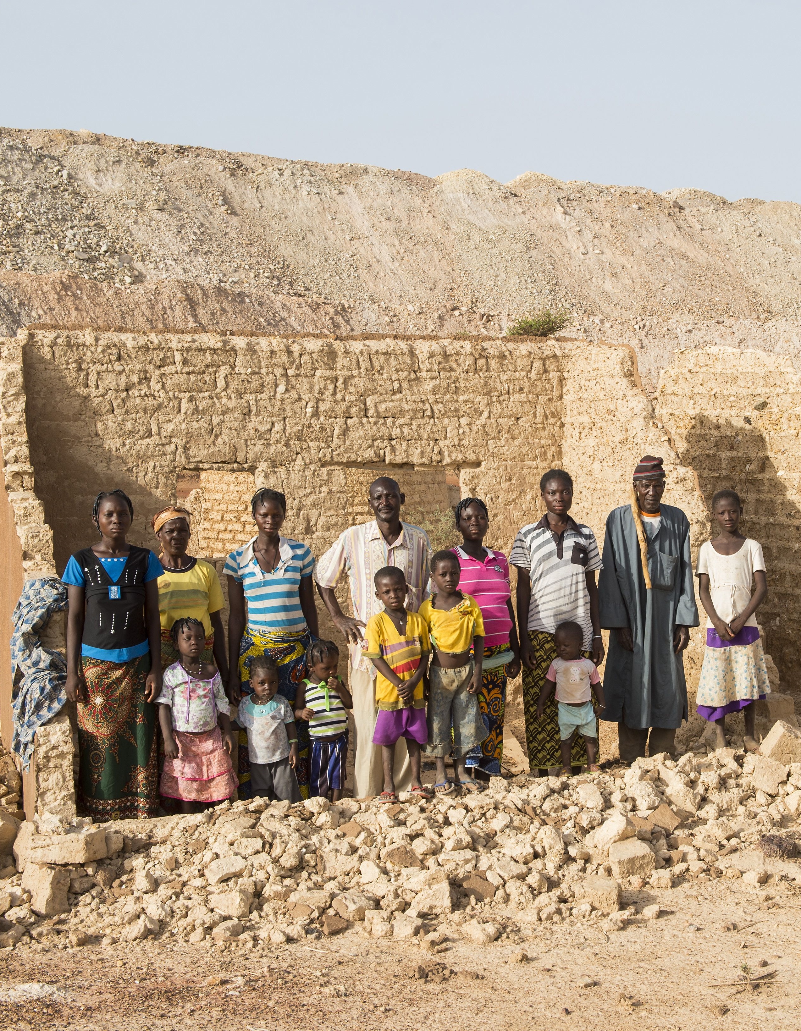 Grossfamilie vor Haus, das die Mine zerstört hat. Foto: Fastenaktion/Meinrad Schade
